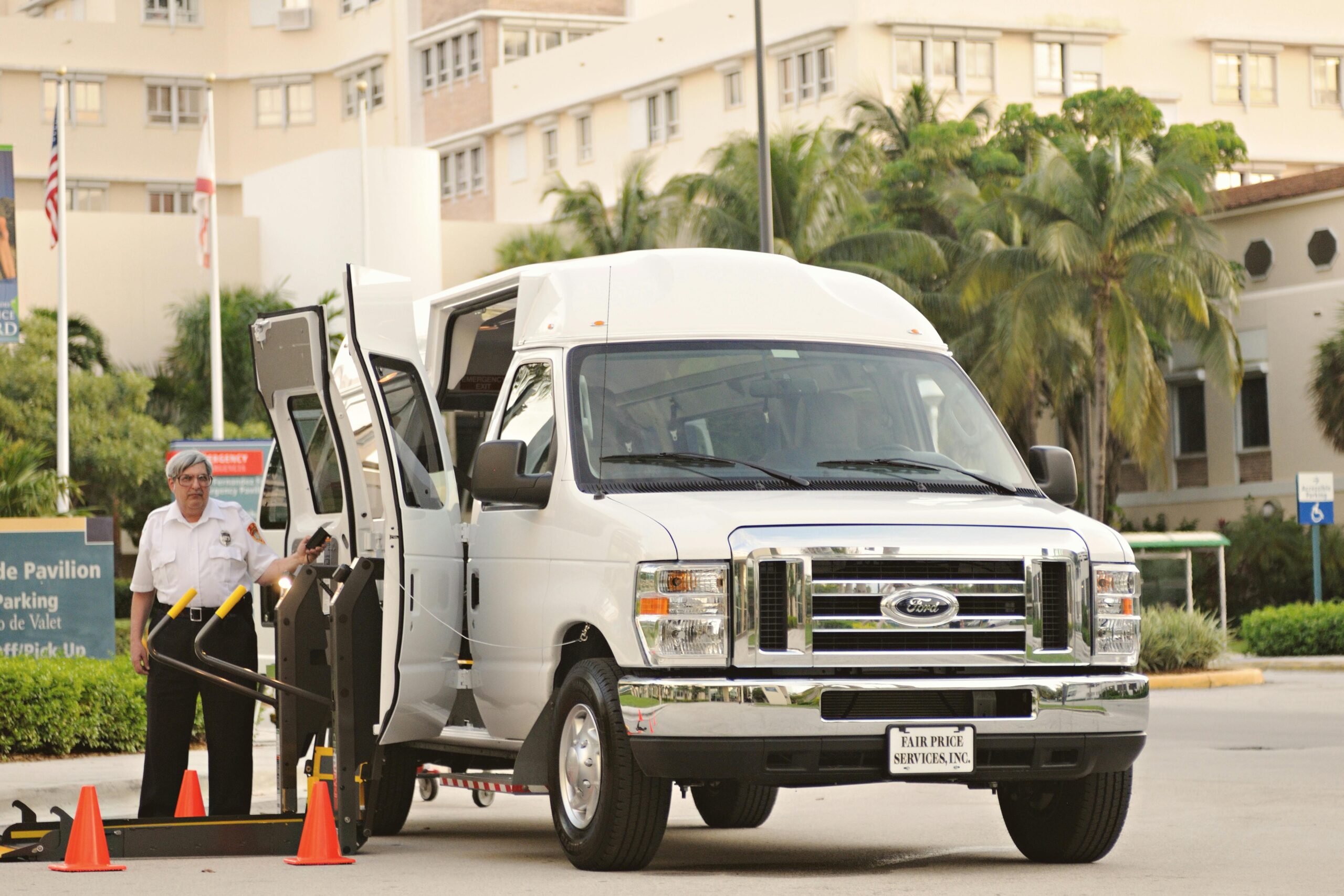 Accessible transportation van prepared for boarding with driver assistance in urban environment.