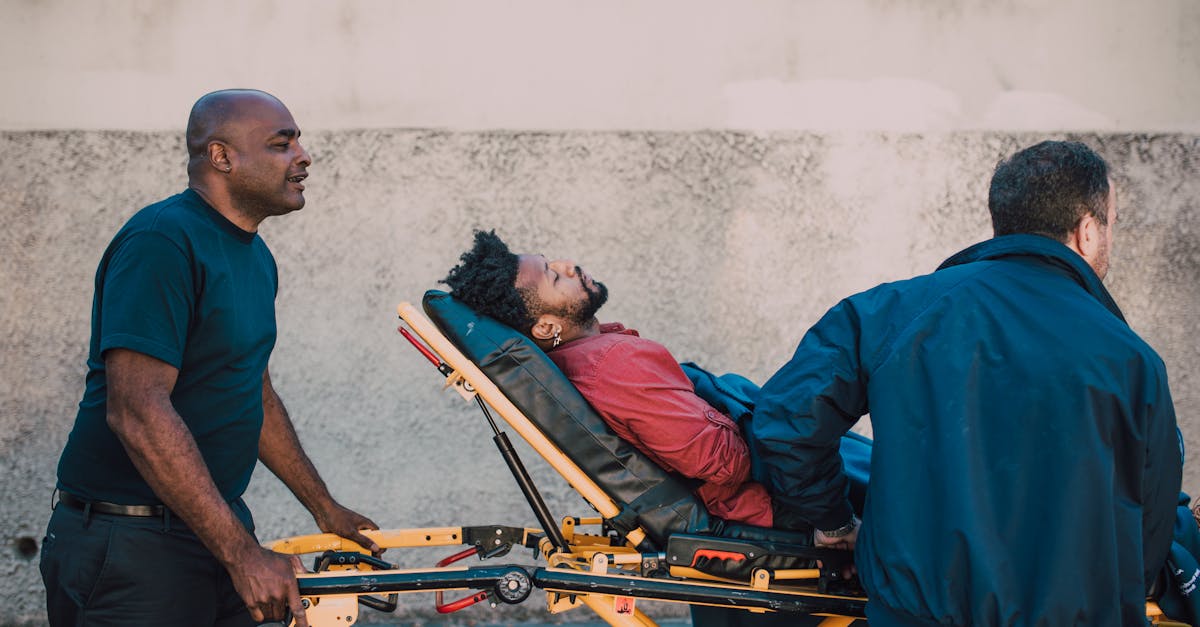 Two paramedics assist an unconscious patient on a stretcher outside. Medical emergency care concept.